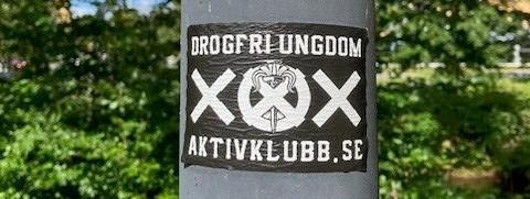 En dekal uppsatt på en lyktstolpe som annonserar aktivklubb. Texten lyder "Drogfri ungdom. Aktivklubb.se"