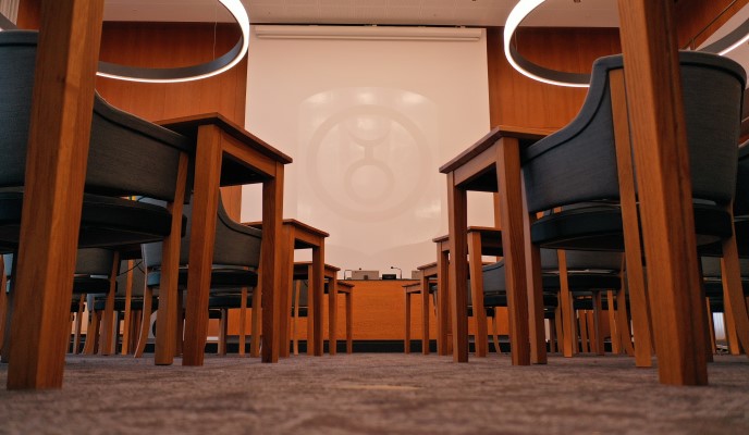 Bild tagen från golvet där man ser stolsben och bord. I bakgrunden syns en vit skräm med Gislaveds kommunvapen. 