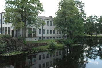 vit byggnad med många fönster vid vatten