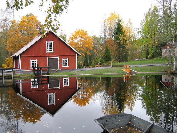 en röd kavrn med stora fönster vid ett vattendrag