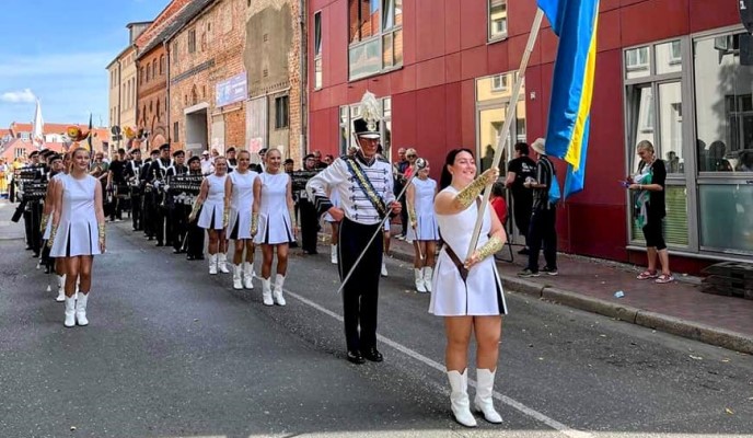 Orkester som marscherar längs en gata.