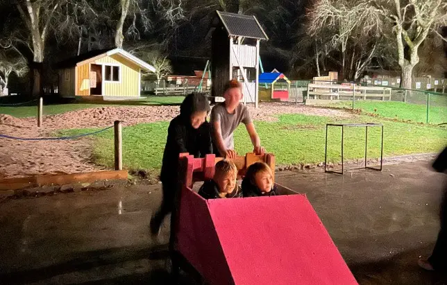 Bild på elever som puttar på en lådbil.