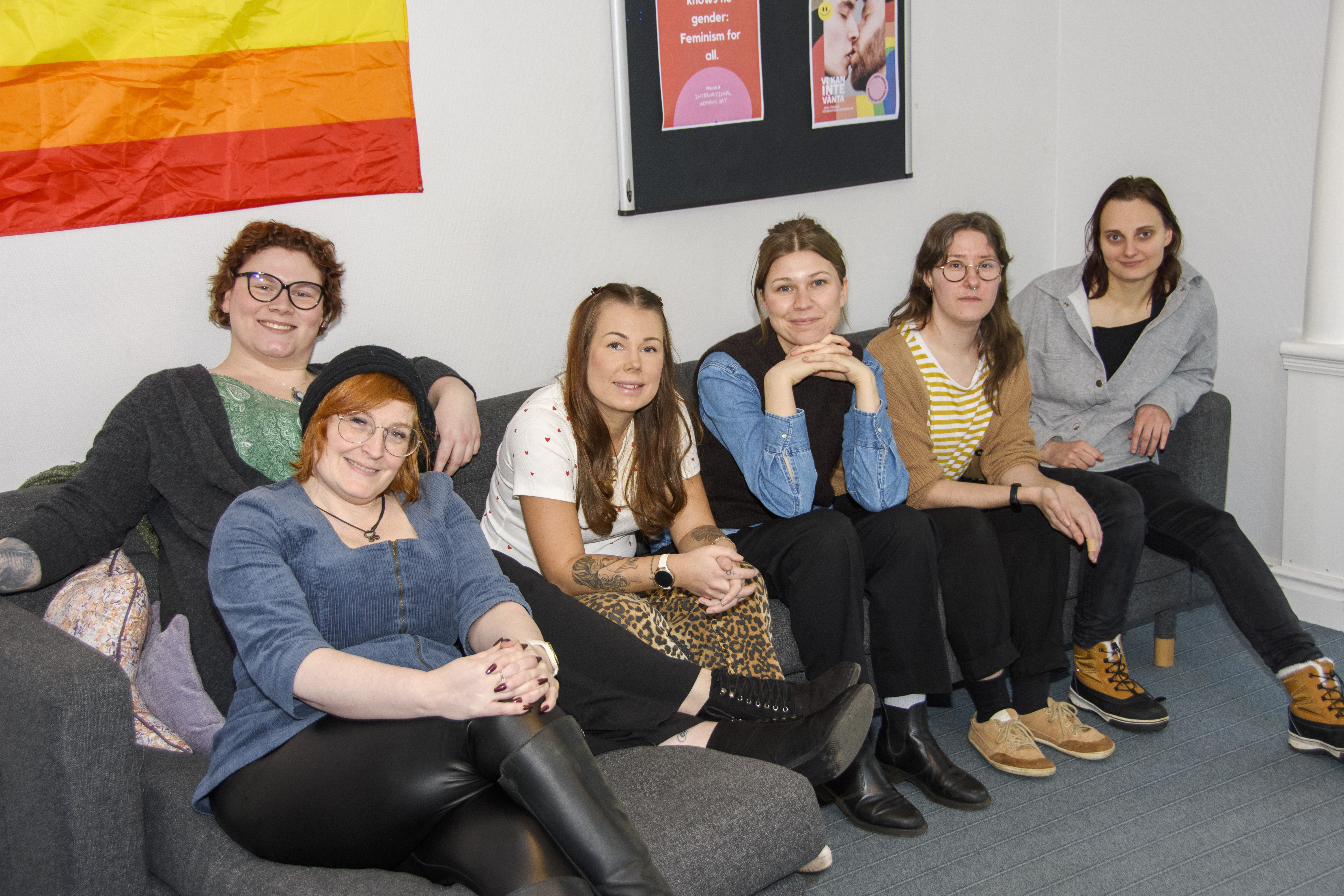 6 kvinnor sitter bredvid varandra i en soffa.