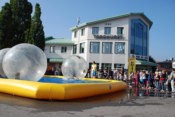 Foto på torghuset i Smålandsstenar. En stor gul upplbåsbarpool med aktiviteter i.