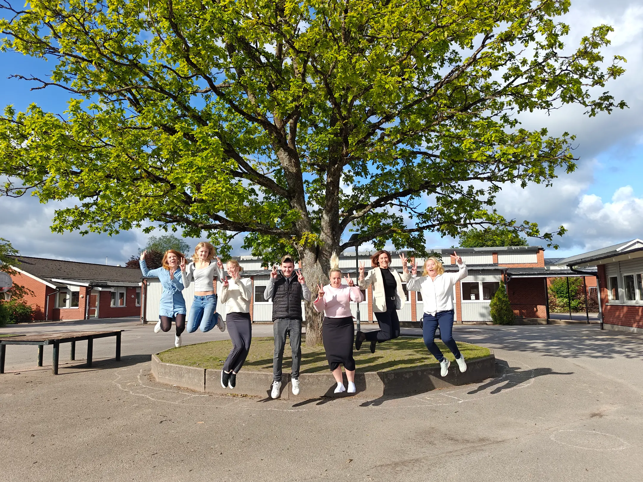 Foto på elever och pedagoger som gör glädjeskutt.