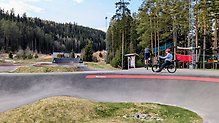 två personer sitter på sina cyklar vid pumptrackbanan på Isaberg.
