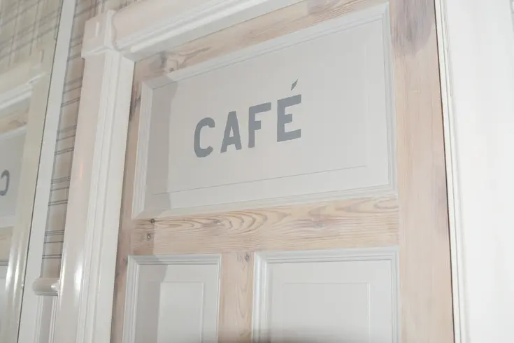En bit av en dörr med texten "Café".