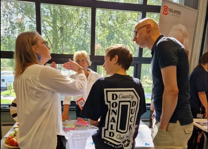 Foto på tre personer i en djup diskussion.