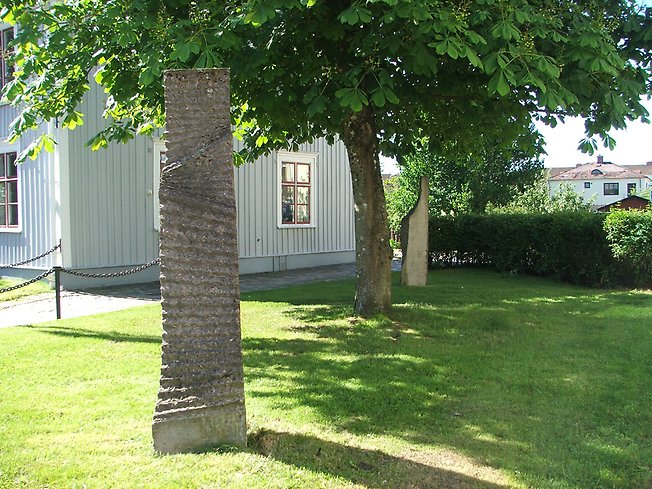 en räfflad, hög sten i en grön park