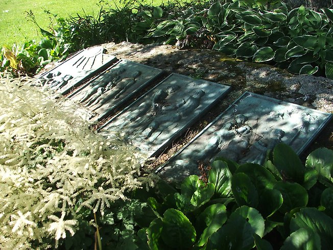 fyra platta stenar med olika motiv på