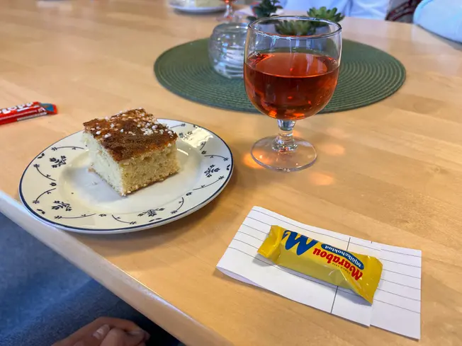 Foto på ett glas med saft och en kaka.