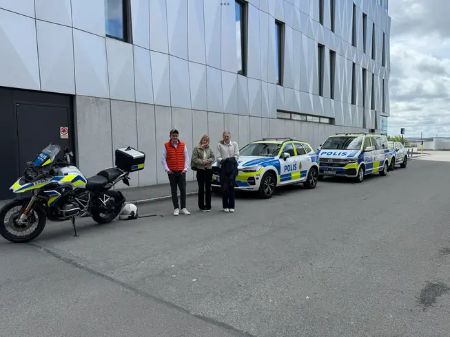 Foto på eleverna framför polisbilar.