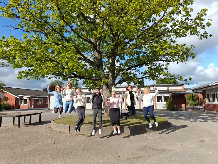 Foto på elever och pedagoger som gör glädjeskutt.