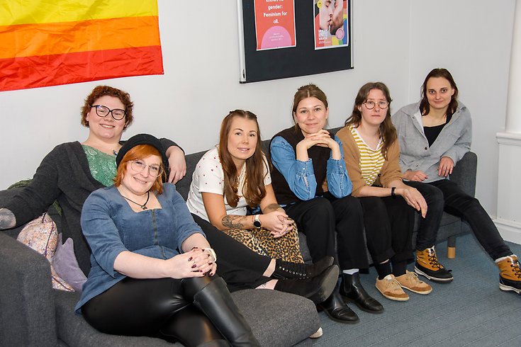 6 kvinnor sitter bredvid varandra i en soffa.