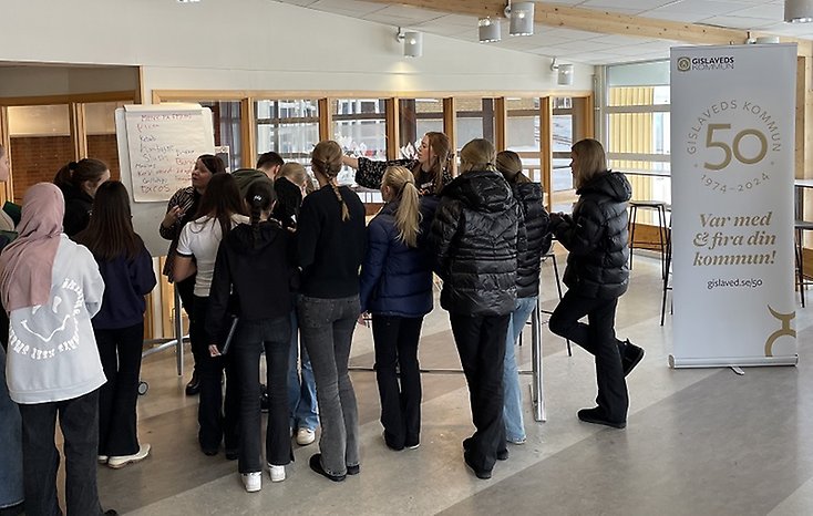 En grupp elever samlas kring kommunens medarbetare.