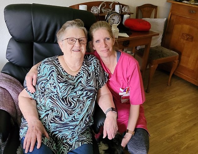 Undersköterska håller armen om vårdtagare.